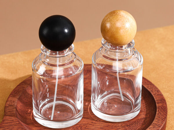 RX019-XB225 100ml clear cylindrical perfume bottle with dark brown light brown and black wood ball lids