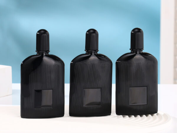 Matte black ribbed glass perfume bottle with gold and black atomizers and matching fluted caps