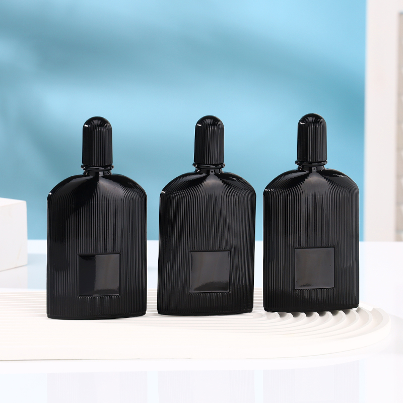 Matte black ribbed glass perfume bottle with gold and black atomizers and matching fluted caps