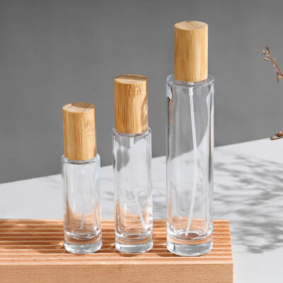 Slim cylindrical clear glass perfume bottles with bamboo caps and gold silver sprayers, various heights