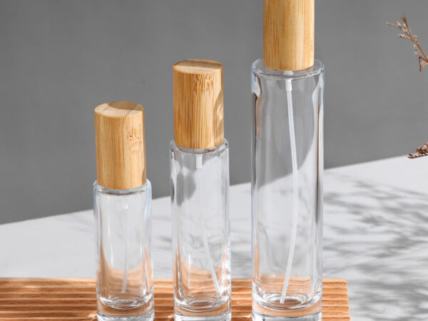 Slim cylindrical clear glass perfume bottles with bamboo caps and gold silver sprayers, various heights