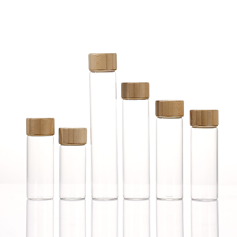 Borosilicate glass jars with screw-on wood caps in bamboo, acacia, and transfer-printed finishes, 12ml to 110ml